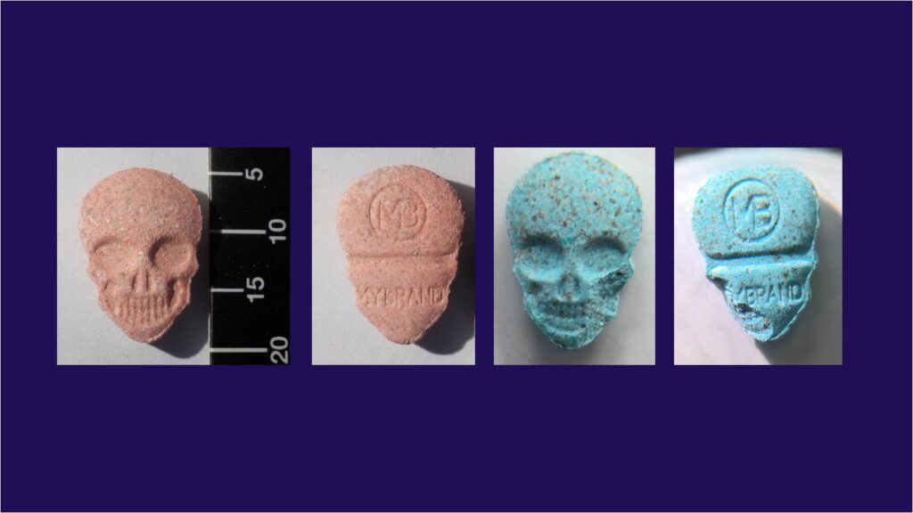 two images of a pink skull-shaped pill, one showing the front and one showing the back of the pill. Two images of a similarly shaped blue-coloured pill. Both pills have an "MB" logo and "mybrand" written on the back.